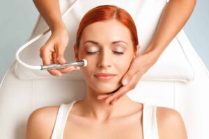 Close up of a happy woman receiving a microdermabrasion facial treatment